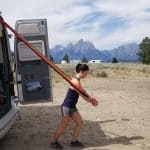 Woman uses elastic bands to workout by RV van
